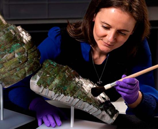 Conservator Bethan Bryan with the Roman arm guard. Source: Duncan McGlynn / National Museums Scotland