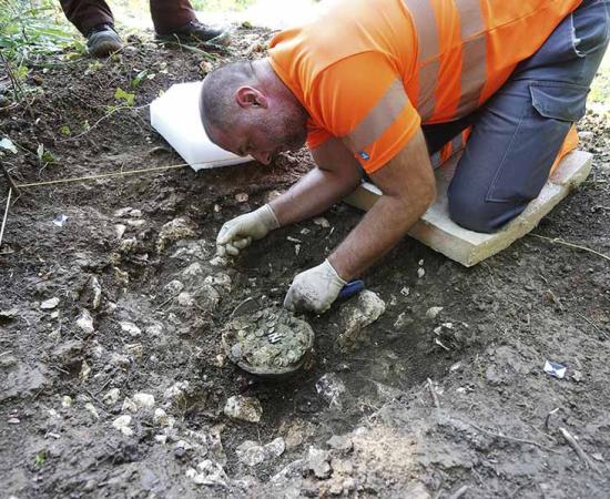 Archaeologist from Archaeology Baselland excavates the pot of Roman coins.	Source: Archaeology Baselland