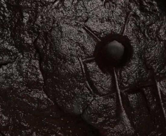 The stone, now known as the Nessglyph, has a circular cup shape and is marked with straight lines carved with a metal implement, looking like a horned deity from the Roman army. Source: Shropshire Council