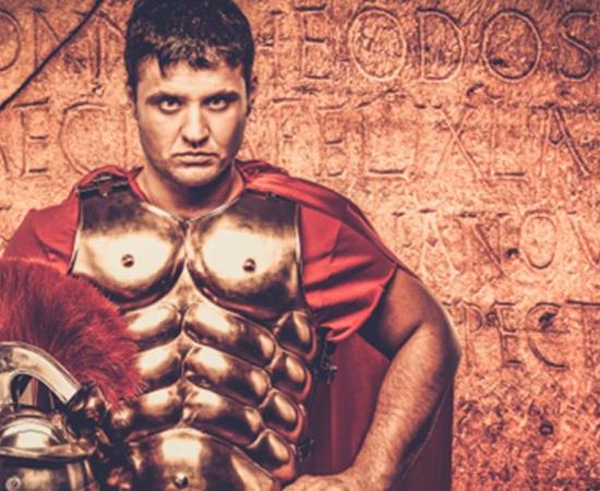 Roman soldier in front of ancient writing. Source: Nejron Photo / Adobe Stock.