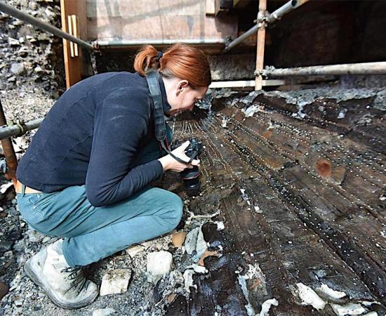 The Roman shipwreck excavated in Porta de Mar, Poreč in Dalmatia, Croatia, together with one of the archaeologists inspecting the find.            Source: Grad Poreč