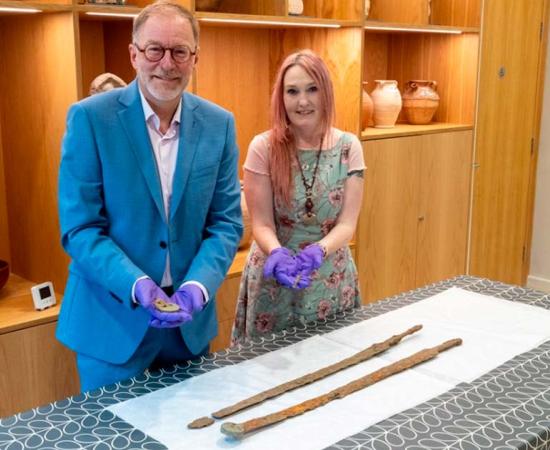 Cllr Paul Hodgkinson, Cotswold District Council Cabinet Member for Leisure, Culture and Health and Emma Stuart, Corinium Museum Director. Proudly exhibiting the Roman swords recently found during a detectorist rally. Source: Cotswold district Council
