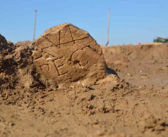 An inscribed section of an altar stone in situ at one of the two Roman temples discovered in Herwin-Hemeling in the Netherlands near the German border. Source: ©RAAP