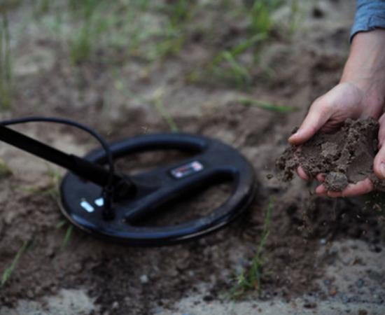 The treasure-hunters. Working with a metal detector. 
