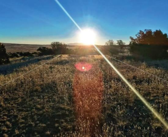 View of the northern parallel Gasco Road on the morning of the winter solstice in 2022, with Mount Taylor directly beneath the sun in the distance.