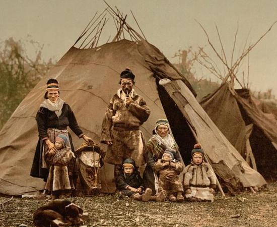 A Sámi family  in front of goahti and lavvu housing, early 1900s, Norway 