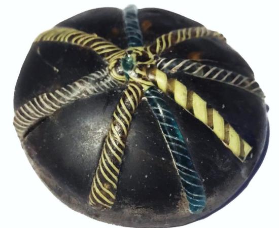 A glass counter decorated with twisted colorful strands was found at the site. 