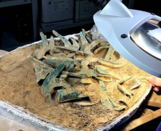 The hoard still cased in the earth it was found in, being processed at the laboratory.