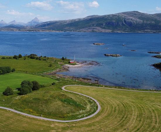 Herlaugshaugen (in the center foreground) from the west, looking towards the strait and the mainland in the background