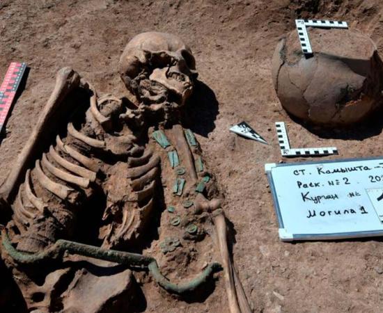 The Siberian charioteer was discovered with a long metal rod with curved hooks on each end laying across the body’s waist area. Archaeologists believe this was once attached to a belt to help the charioteer tie the reins and free up their hands. Source: IAET SB RAS