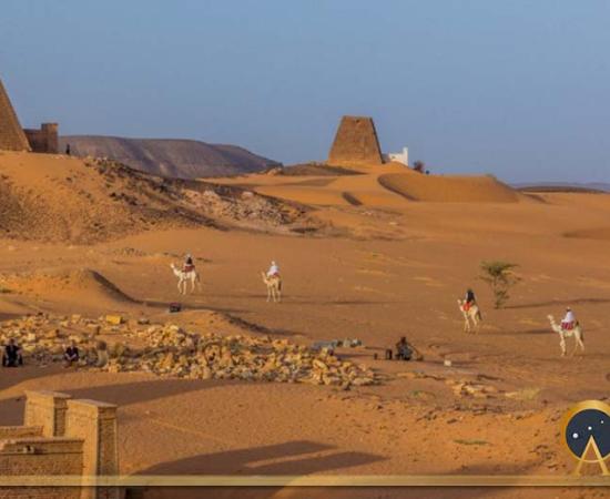 Locals on camels near Meroe pyramids, Sudan (Matyas Rehak/ Adobe Stock)