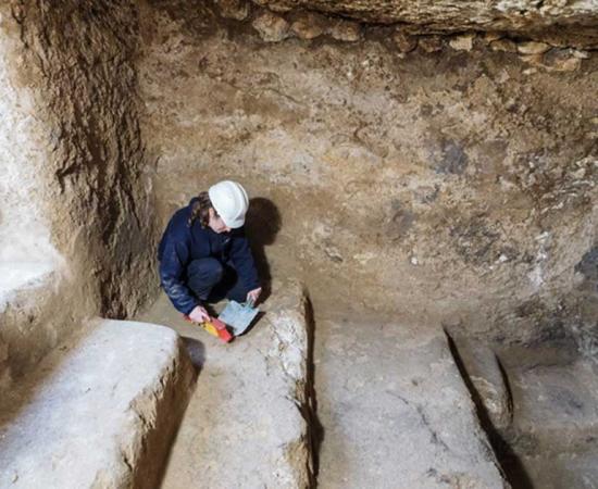 An archaeologist collects material in an underground chamber that may have been a hideout for rebels during the Bar Kokhba Revolt of the 2nd century AD. 