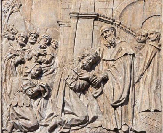 A baroque carved relief (at the Church of Saint Benedict in Venice, Italy) from the life of St. Benedict showing Totila, the king of Ostrogoths, on his knees. During the invasion of Italy, Totila ordered a general to wear his kingly robes to see whether St. Benedict would discover the truth. Immediately Benedict detected the impersonation. Impressed, Totila came to pay his respects to the man of the cloth. Totila was the leader of the Ostrogoths in the Third Siege of Rome. Source: Renáta Sedmáková / Adobe S