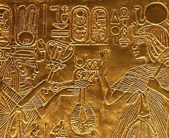 Scene from gilded shrine of Tutankhamen showing him and his wife Queen Ankhesenamun. Queen hols a sistrum and menat. 