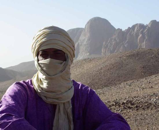 Tuareg man with his traditional tagelmust face and head covering in the mountains of Hoggar, Algeria.	 Source: Sahara Nature / Adobe Stock 