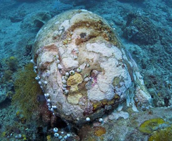 Stone head of lord Buddha photographed during a dive at the Temple, near Pemuteran, Bali