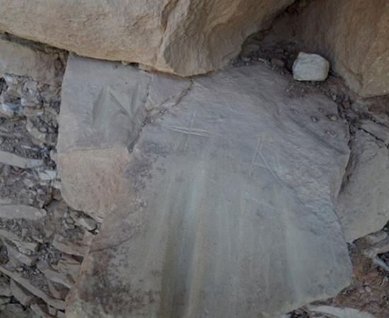 Letters and shapes crudely scratched into prehistoric grinding slicks on the Petroglyph Point Trail, permanently damaging these artifacts.