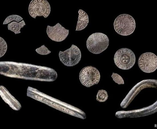 The treasure found by a Welshman with a metal detector includes silver pennies and coin fragments from the time of King Cnut of England and Scandinavia. 