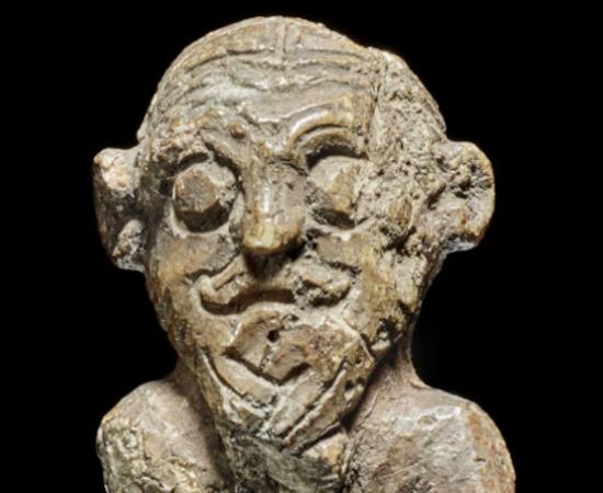 The small walrus ivory figurine discovered in Denmark's National Museum, showing intricate Viking hairstyling 