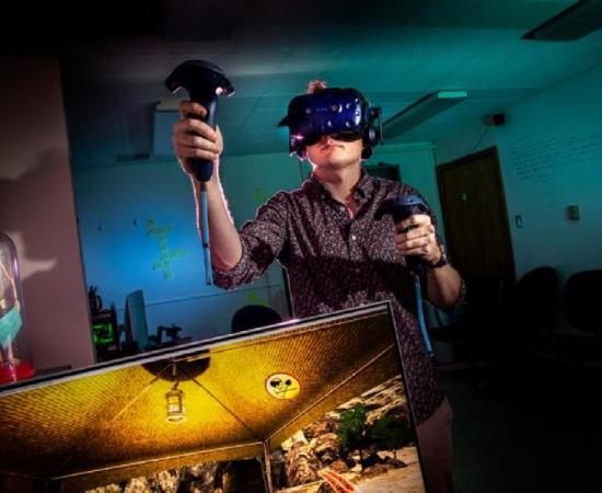 Computer science graduate student and project manager Cameron Merrill explores a virtual archaeology cave excavation experience he helped create. Source: Fred Zwicky / University of Illinois