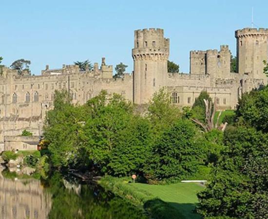 Warwick Castle from the bridge over the River Avon, Warwick, Warwickshire, UK.