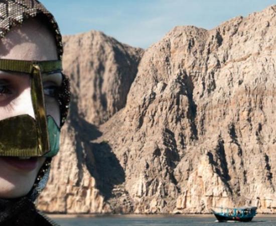 Deriv; Woman with veil and scarf and Khor Ash Sham, Musandam Peninsula, Oman. 