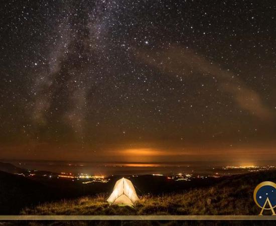 Milky way seen from a grassy summit in, Nantlle Valley in Gwynedd, Wales.( Chin / Adobe Stock)