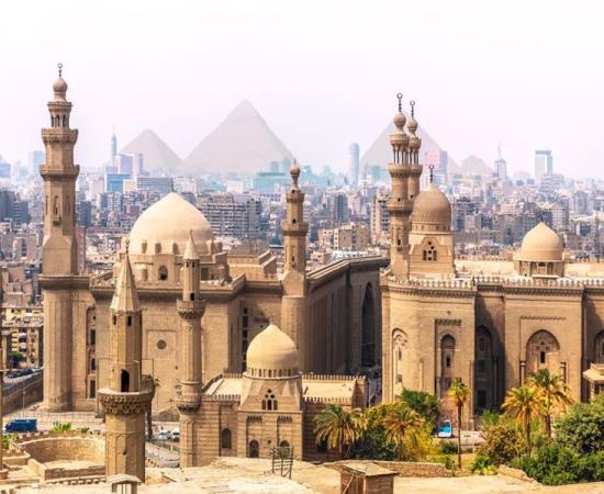 The Mosque-Madrassa of Sultan Hassan and the Pyramids in the background, Cairo, Egypt. Source: AlexAnton / Adobe Stock