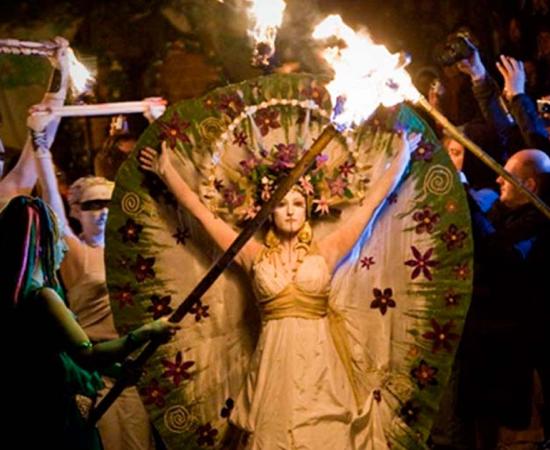 Lady parading with followers bearing torches, at the ancient Celtic festival of Beltane, marking the beginning of summer.	Source: chrisdonia/CC BY NC SA 2.0