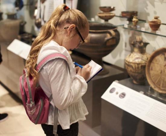 Student studying artifacts in a museum. Credit: Monkey Business / Adobe Stock
