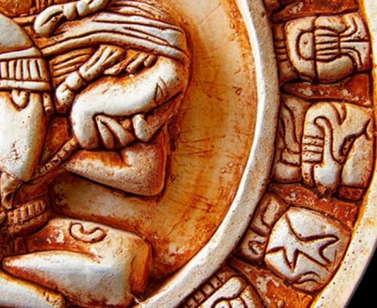 Closeup of glyphs on a Mayan calendar. Credit: zimmytws / Adobe Stock