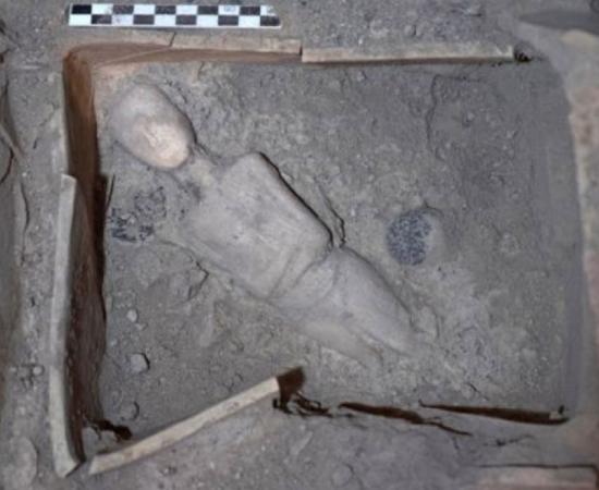 Marble protocycladic female figurine, placed diagonally at the bottom of the shrine covered by an ancient volcanic eruption.