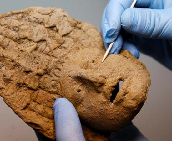 A baked clay theater mask that was discovered among the grave goods provides information about the people whose bodies were buried in the chamber. 
