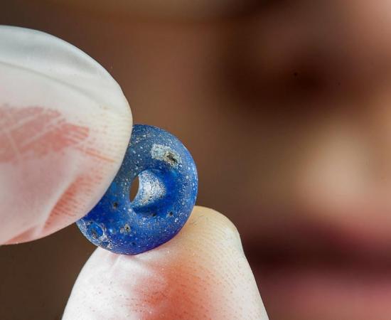 A blue glass bead at least 1,500 years old is among the finds archaeologists have made at the Ørland Main Air Station dig. 