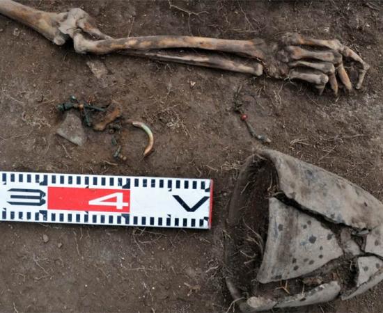 A closeup of the Tagar female grave (excavated in the Siberian steppe Minusinsk basin), which is an anomaly because the bone amulet next to her wrist is made with one piece of human bone, suggesting secondary burial grave manipulation.		Source: Evgeniy Bogdanov / Haaretz