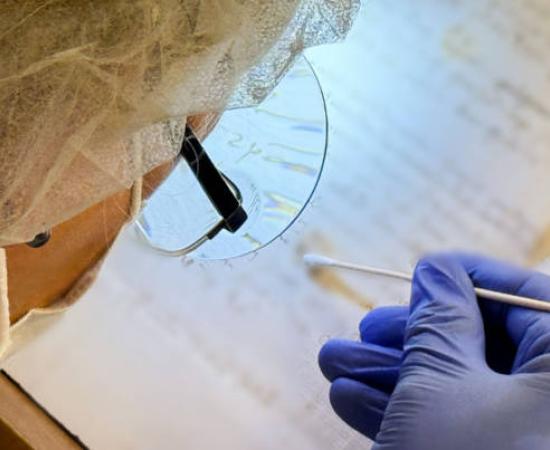 Artist Karina Åberg swabs a 14th century da Vinci family letter from the State Archive in Prato