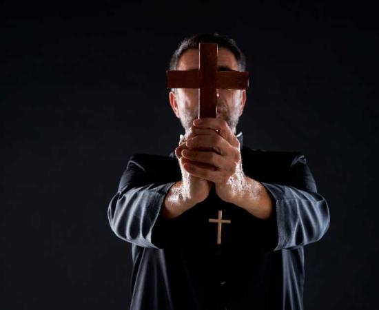 Priest conducting an exorcism. Source:  lunamarina / Adobe Stock