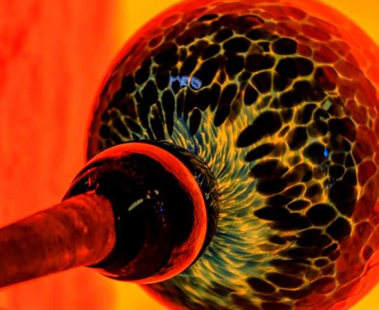 Glassblowing processs, with a ball of glass being heated by a kiln. Source: SvetlanaSF / Adobe Stock