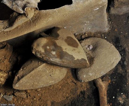 Three of the hearts in their urns on top of the earth in which they were buried 
