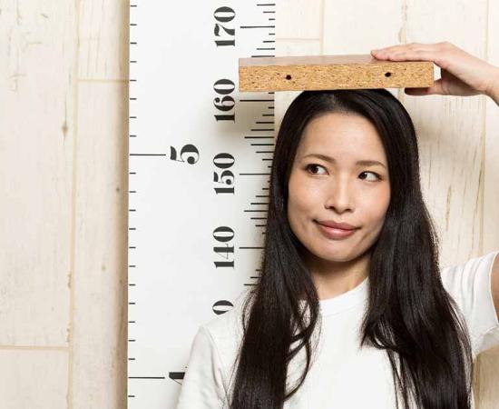 Woman measuring her height.	Source: kei907/Adobe Stock