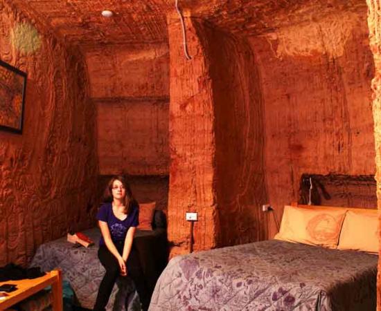 A woman sits in an underground hotel room in Coober Pedy