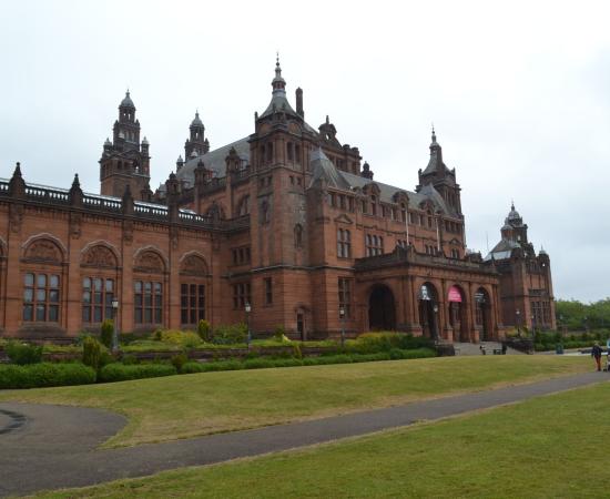 Red sandstone exterior of Kelvingrove Art Gallery and Museum behind a lawn