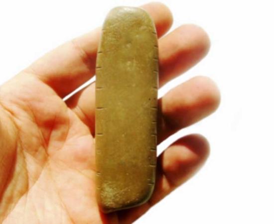 The 10,000-year-old pebble which is believed to be the oldest lunar calendar in the world. Source: SAPIENZA, Università di Roma