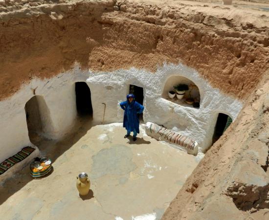 A whitewashed sunken courtyard in the Matmata area of Tunisia, with doorways cut into the surrounding walls