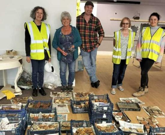 Dyfed Archaeological Trust diggers standing in front of the boxes of artifacts found at what is thought to be the medieval friary site in Haverfordwest, Wales. Source: Dyfed Archaeological Trust