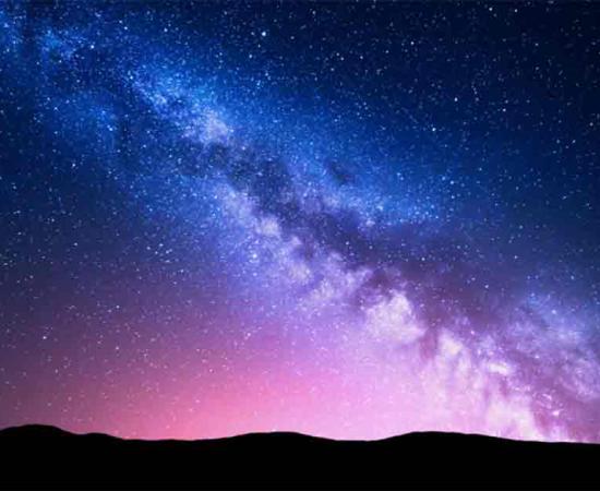 Milky Way and pink light over mountains. Source: den-belitsky/Adobe Stock