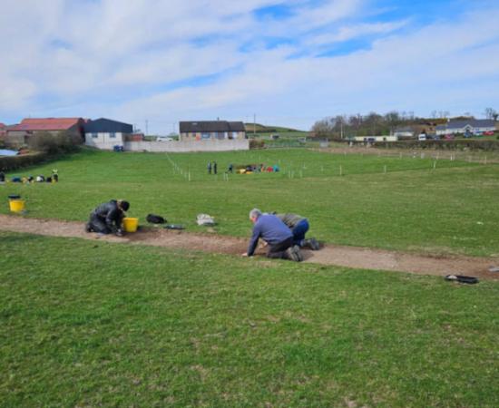 Teams of volunteers performing excavations in the rural area of Northern Ireland where the remains of the 12th century monastery have been found.