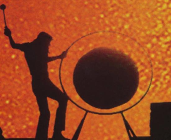 Roger Waters banging a gong from the top of the amphitheater at sunset during the filming of Pink Floyd’s concert at Pompeii.