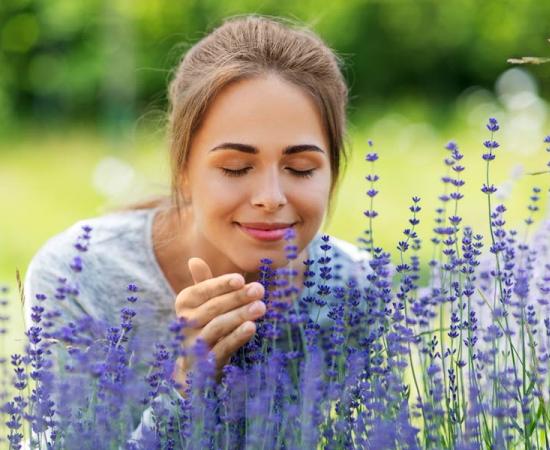 Woman enjoying the scent of a flower. Source: Syda Productions / Adobe Stock