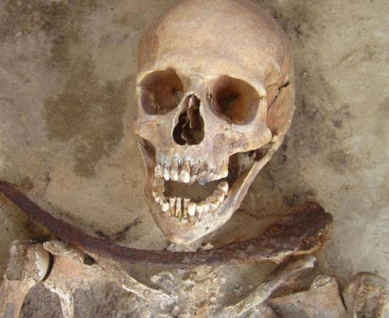 30-39 year old female’s remains with iron sickle placed across neck